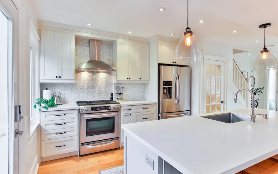 Cream shaker kitchen with a stainless range hood and warm oak flooring